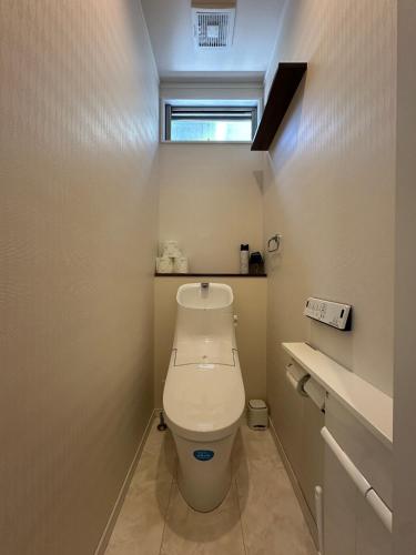 a small bathroom with a toilet with a window at リゾートヴィラ宮島 Sunset terrace in Hatsukaichi