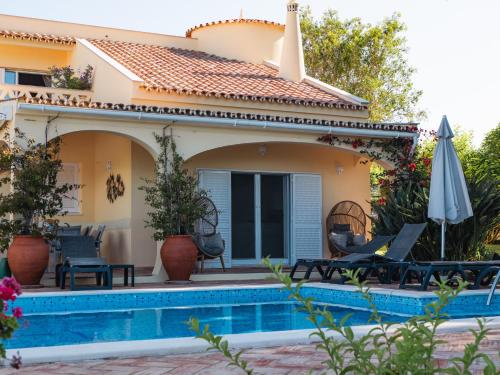 a villa with a swimming pool and a house at Beach villa Casa de Amanhã 450 mts to the beach with beautiful garden and heated saltwater pool in Albufeira