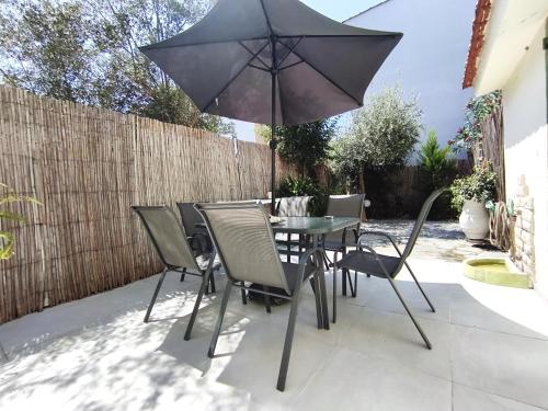 a table and chairs with an umbrella on a patio at Casa Mameli Αpartments in Kallithea Halkidikis
