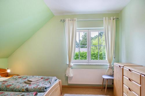 a bedroom with a bed and a window at Sandhasen in Rimlos