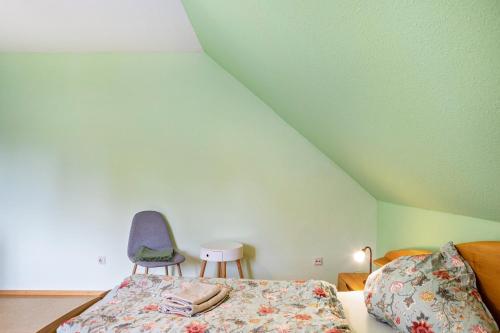 a bedroom with a bed and a blue chair at Sandhasen in Rimlos