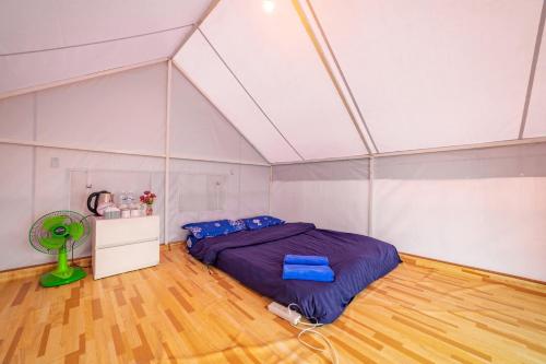 a bedroom with a bed and a fan in a room at ม่อน ซากุระ ม่อนแจ่ม in Mon Jam