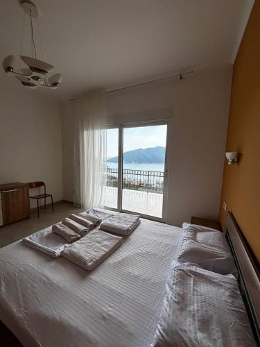a bedroom with a large bed with a large window at Villa Smokovac in Risan