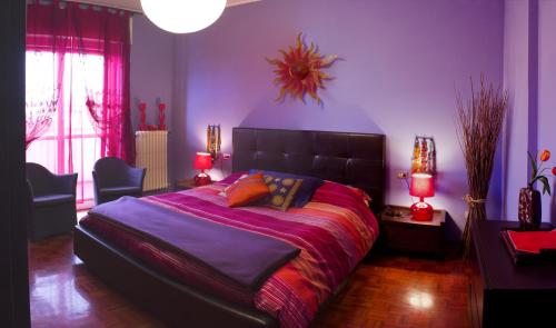 パヴィアにあるB&B Students homeの紫の壁のベッドルーム1室(大型ベッド1台付)