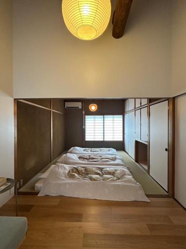 a large room with four beds in it at 大津ゲストハウス 栖碩 Seiseki in Otsu