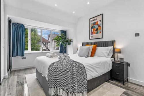 a bedroom with a large bed and a window at Large Group StayI 5BR I Near Stadium & Tubes I Free Parking in London