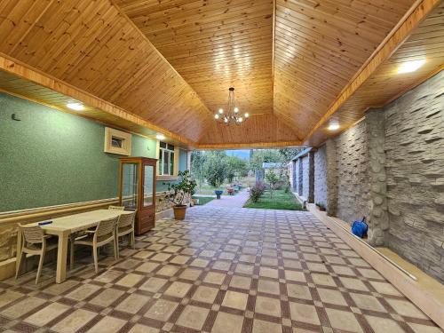 a large room with a wooden ceiling and a table and chairs at Lush Paradise in Gabala