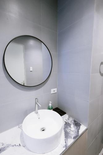 a bathroom with a white sink and a mirror at ACHITEL Tarlac in Tarlac