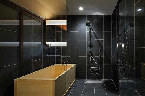 a bathroom with a shower and a wooden tub at UNO RETREAT Kyoto Gluten Free & Vegan Hotel in Kyoto