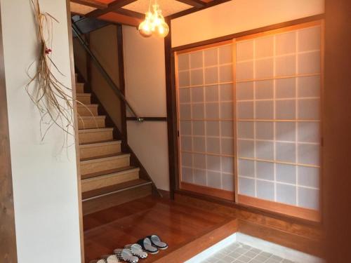 a room with a staircase and a group of shoes at KINOSAKI KNOT female only - Vacation STAY 25710v in Toyooka