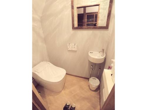 a bathroom with a toilet and a sink and a mirror at KINOSAKI KNOT female only - Vacation STAY 25710v in Toyooka
