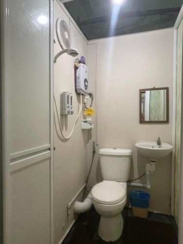 a bathroom with a toilet and a sink at Warisan Family inn @ Seafront in Semporna