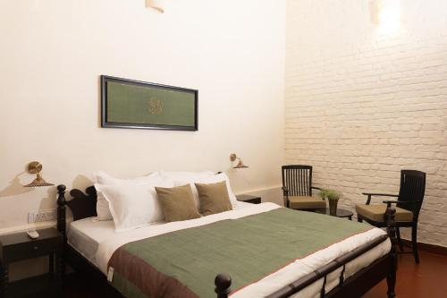 a bedroom with a bed and a white brick wall at Maqbara 27 in Lucknow
