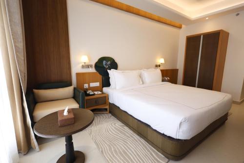 a hotel room with a bed and a chair at Royal Bishnu in Baharampur
