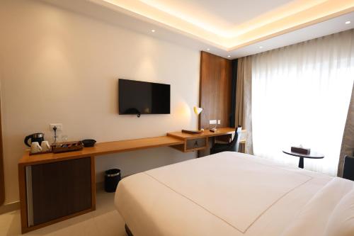 a hotel room with a bed and a television on a wall at Royal Bishnu in Baharampur