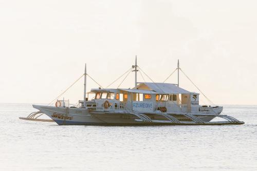 a boat is sitting in the water at Azure Dive Resort in Dauin