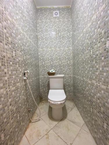 'Aïn BenianにあるMagnifique Duplex Vue Mer 4 chambres Bénianのタイル張りの壁のバスルーム(トイレ付)