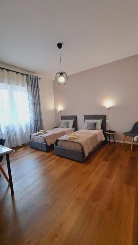 two beds in a large room with wooden floors at Casa Rodolfi, Vicenza in Vicenza