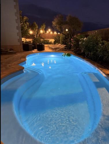 a large blue swimming pool at night at Traumhafte Finca auf Mallorca mit Pool 1A Lage direkt am Meer bei Es Trenc Bootstouren auf Anfrage möglich in Sa Ràpita