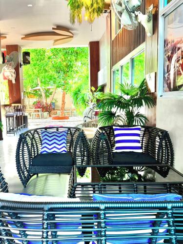a patio with chairs and a table with blue and white pillows at Anchan Hotel & Spa in Hua Hin