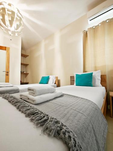 two beds sitting next to each other in a bedroom at Cozy Retreat in San Ġwann
