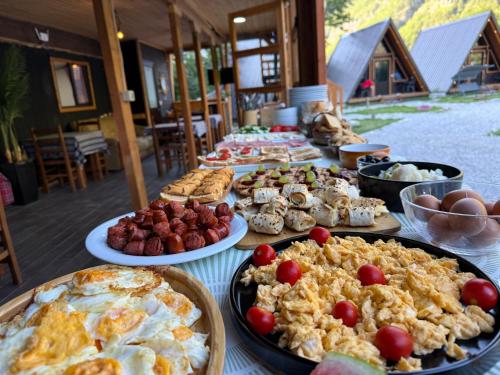 a table with many different types of food on it at Thethi Villas in Theth