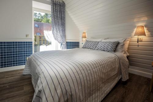a bedroom with a bed and a window at Vila Stinta in Juodkrantė