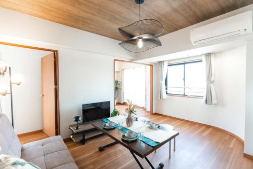 a living room with a couch and a table at JR住吉駅徒歩30秒 眺望抜群の貸切ペントハウスLn30 in Kobe