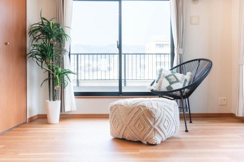a room with a chair and a large window at JR住吉駅徒歩30秒 眺望抜群の貸切ペントハウスLn30 in Kobe