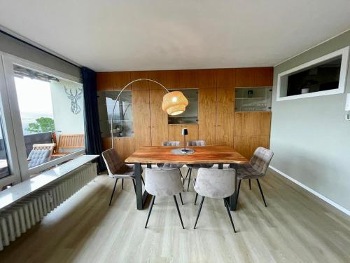 Un comedor con mesa y sillas de madera. en Panorama-Apartment mit Rhein-, Loreley- und Burgenblick direkt am Rheinsteig, en Patersberg