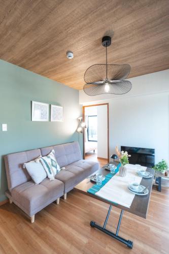 a living room with a couch and a table at JR住吉駅徒歩30秒 眺望抜群の貸切ペントハウスLn30 in Kobe