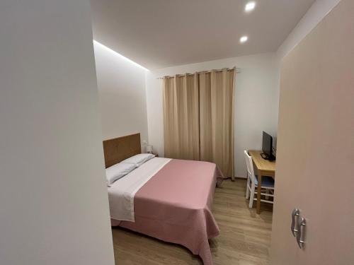 a small bedroom with a bed and a desk at B&B Marina Bay in Pineto