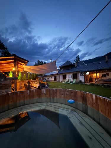 a swimming pool in a backyard at night with a tent at Vila Eruga- Apartament 3 in Poiana Mărului