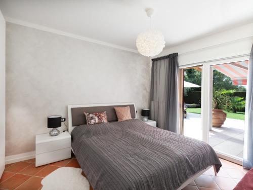 a bedroom with a bed and a large window at Ca' dei Vigneti in Colà di Lazise