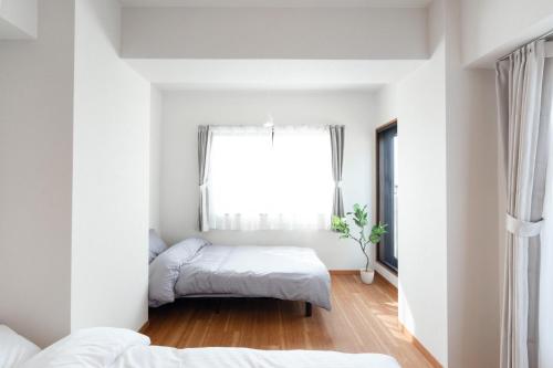 a bedroom with two beds and a window at JR住吉駅徒歩30秒 眺望抜群の貸切ペントハウスLn30 in Kobe