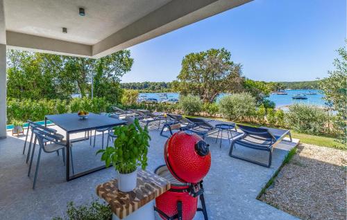 a patio with a table and chairs and a view of the water at Cozy Home In Medulin in Medulin