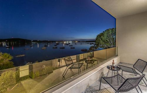 a balcony with chairs and a view of a lake at Cozy Home In Medulin in Medulin