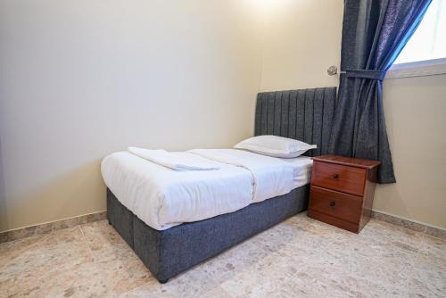a small bedroom with a bed and a window at ركن صحاري للشقق المخدومة العليا Rukn Sahari for Served Apartments in Tabuk
