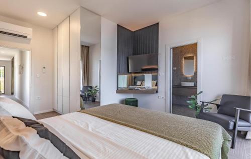 a bedroom with a large bed and a chair at Cozy Home In Medulin in Medulin