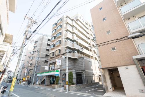 a tall building on a city street at JR住吉駅徒歩30秒 眺望抜群の貸切ペントハウスLn30 in Kobe