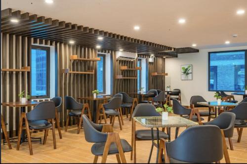 a restaurant with tables and chairs and windows at Pearl Hotel Tuan Chau - Ha Long in Ha Long