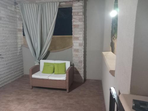 a chair with two green pillows in a room at Paradiso House in Torre Ovo