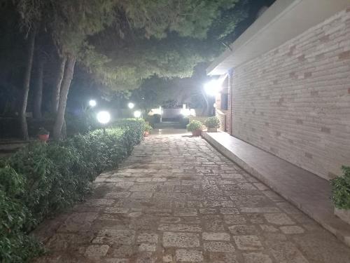 a stone walkway at night with lights on a building at Paradiso House in Torre Ovo