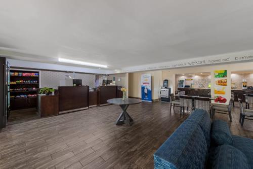 a lobby with a couch and a table and a kitchen at Quality Inn & Suites Airport in Charlotte