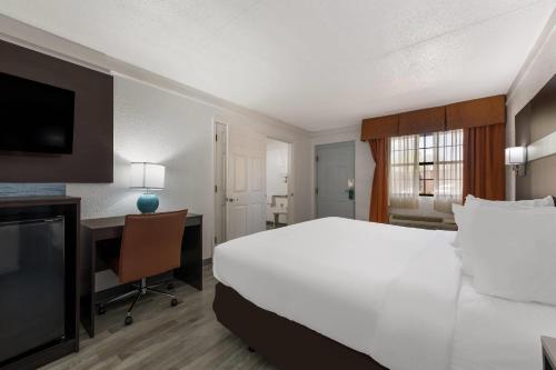 a hotel room with a large bed and a desk at Quality Inn & Suites Airport in Charlotte
