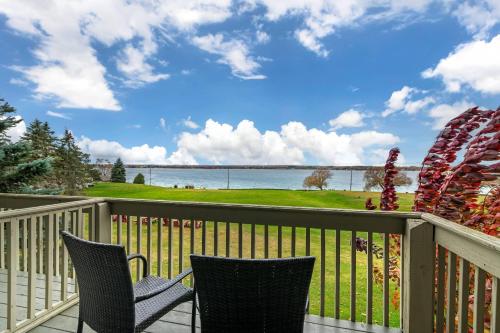 a balcony with two chairs and a view of the water at The Inn at Gran View Ogdensburg, an Ascend Collection Hotel in Ogdensburg