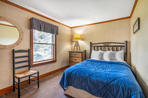 a bedroom with a bed and a chair and a window at The Inn at Gran View Ogdensburg, an Ascend Collection Hotel in Ogdensburg