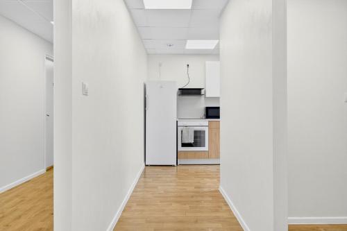 an empty kitchen with white walls and wooden floors at Angaar - Tallinn Airport in Tallinn