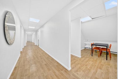 a white hallway with a table and a mirror at Angaar - Tallinn Airport in Tallinn