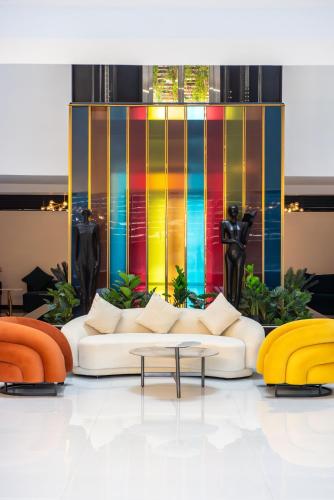a living room with a white couch and a colorful wall at Kingfisher Nest Hotel Suites- Westlands, Near Sarit Center in Nairobi